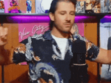 a man wearing a shirt with a dragon on it stands in front of a pink sign that says new york city