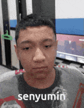 a young man wearing a t-shirt that says senyumin on it