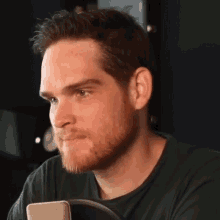 a man with a beard wearing a green shirt