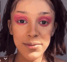 a close up of a woman 's face with pink eyeshadow on