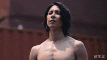 a man without a shirt is standing in front of a netflix logo