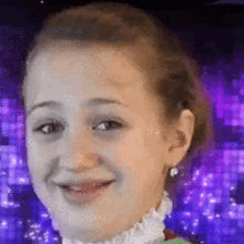 a young girl is smiling with a purple background in the background