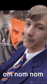 a man in a suit and tie is next to another man in a striped shirt
