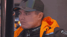 a man wearing a monster energy jacket looks to the side