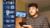 a man is holding a cell phone in front of a screen that shows the time as 11:15 27 .