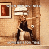 a woman is sitting on a toilet in a bathroom with her arms outstretched .