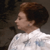a close up of a woman 's face with a floral shirt