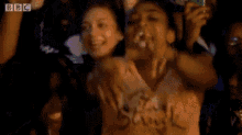 a woman wearing a shirt that says struck stands in a crowd