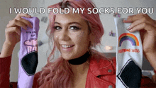 a woman with pink hair is holding up a pair of socks that say i would fold my socks for you ..