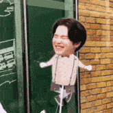 a cardboard cutout of a man with suspenders and a bow tie is hanging on a window .