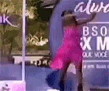 a woman in a pink dress is hugging another woman in front of a sign that says bso xm