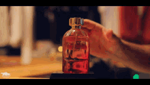 a bottle of milano perfume is being held by a hand