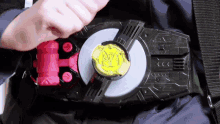 a person is holding a toy belt with a yellow emblem on it