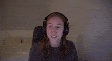 a woman wearing headphones is sitting in a chair .