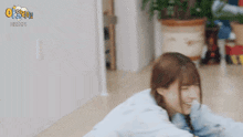 a woman is laying on the floor with a pillow on her head and laughing .