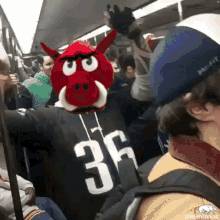 a man wearing a jersey with the number 36 on it is riding a train