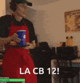 a man in a red apron is holding a tray with a blue cup on it and the words la cb 12