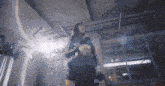 a woman standing in a dark room holding a black bag that says ' n ' on it
