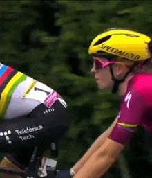 a cyclist wearing a yellow specialized helmet and sunglasses