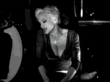 a black and white photo of a woman wearing a necklace with a cross on it