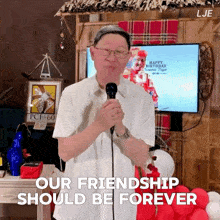 a man speaking into a microphone with the words " our friendship should be forever "