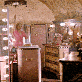 a woman in a pink dress is standing in front of a mirror in a dressing room