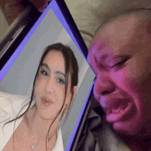 a man is crying while looking at a picture of his girlfriend