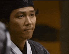 a man wearing a black headband making a funny face with his tongue out