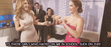 two women are dancing in a room with the caption to those girls who hated on me in school suck on this .