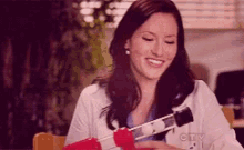 a woman is sitting at a table with a cbs logo on her shirt .