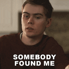 a man in a brown sweater with the words somebody found me on the bottom