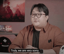 a man with glasses and a watch says truly we are very sorry