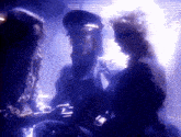 a group of people are standing in a dark room talking to each other