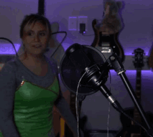 a microphone is sitting in front of a purple wall with guitars hanging on it