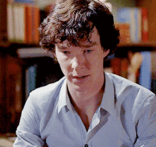 a man with curly hair wearing a blue shirt