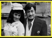 a black and white photo of a man and woman standing next to each other .