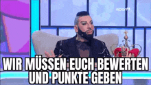 a man with a beard is sitting in a chair with a crown on his head and says wir müssen