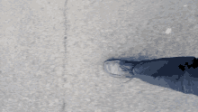 a person 's foot is standing on a crack in the ground