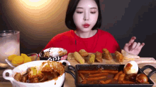a woman in a red shirt is eating a variety of foods