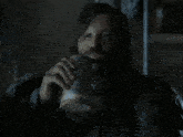 a man with long hair and a beard is drinking from a mug