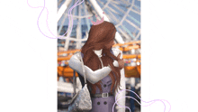 a woman wearing a purple dress and a pink crown stands in front of a roller coaster