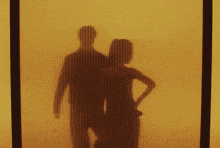 a shadow of a man and woman behind a striped curtain
