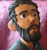 a clay sculpture of a man with a beard and big eyes