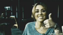 a woman is smiling and giving a thumbs up with gifwave.com in the corner