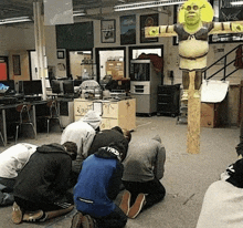 a group of people kneeling in front of a shrek statue