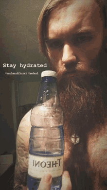 a man with a beard is holding a bottle of water with the words stay hydrated above him