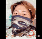 a man wearing a scarf around his face with snow falling on it