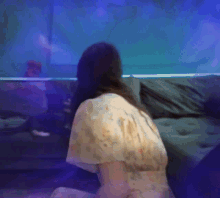 a woman is sitting on a couch in front of a blue wall