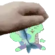 a hand is holding a green cartoon character with a fish in its mouth .
