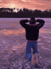 a person kneeling on the ground with their hands behind their head